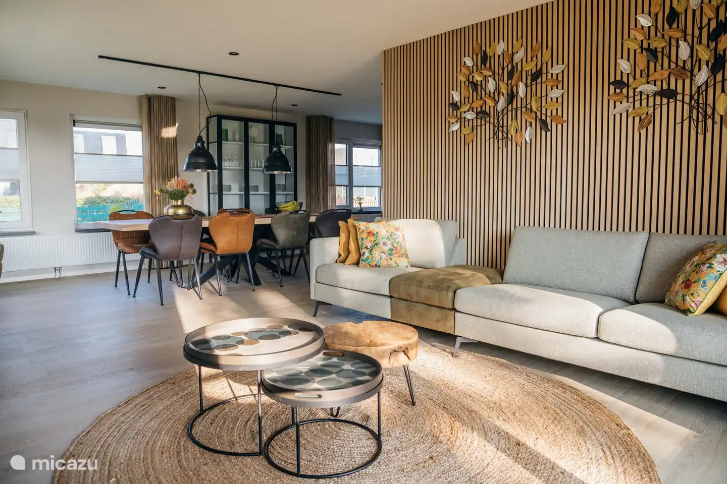 Sfeervolle woonkamer met open haard en openslaande tuindeuren en een grote zithoek voorzien van een Smart TV.