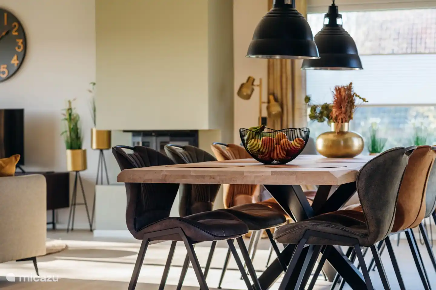 Sfeervolle woonkamer met open haard en openslaande tuindeuren en een grote zithoek voorzien van een Smart TV.