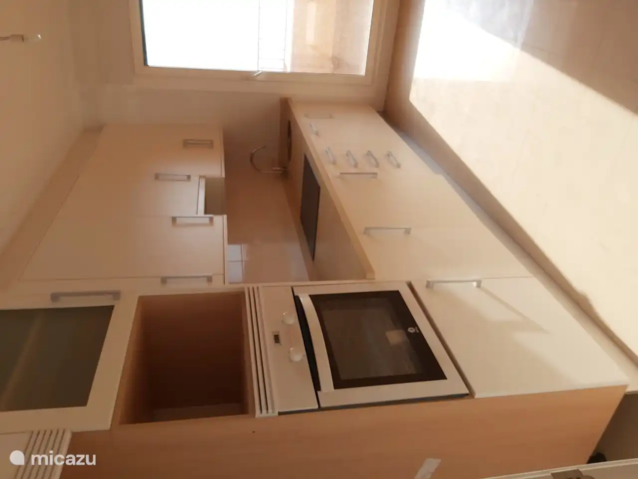 Küche mit Waschmaschine, Kühlschrank mit Gefrierfach, Geschirrspüler und Herd