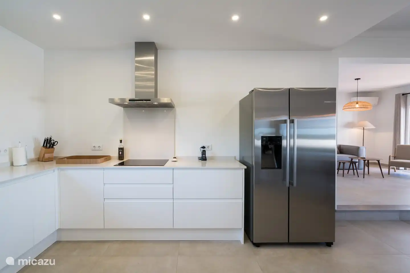 Die Küche mit Induktionskochfeld, Dunstabzugshaube, amerikanischem Kühlschrank mit Eiswürfeln und trinkbarem gekühltem Wasser.