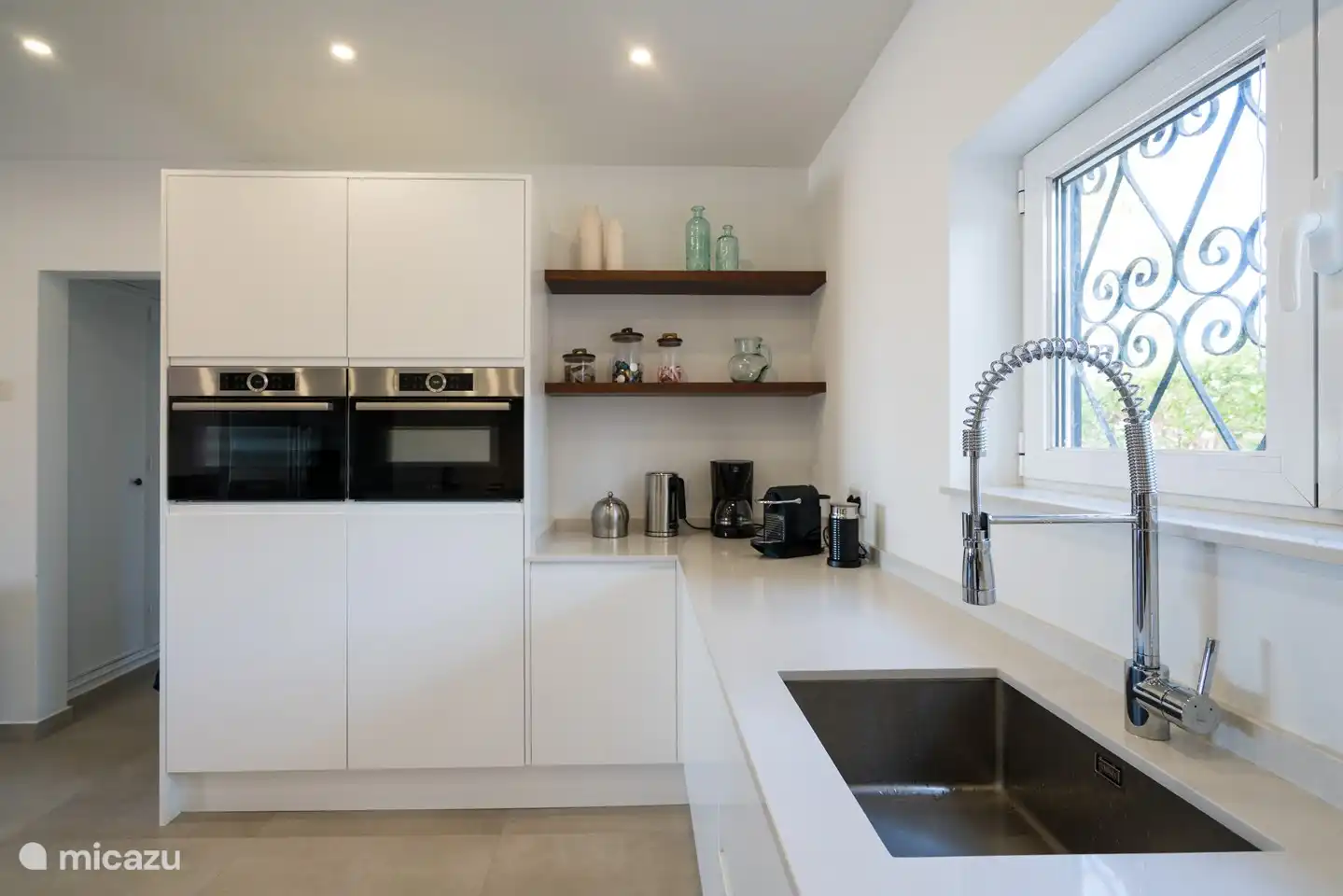 Die Küche mit Backofen und Kombibackofen mit Mikrowelle, Nespresso-Kaffeemaschine, Filterkaffeemaschine, Wasserkocher.