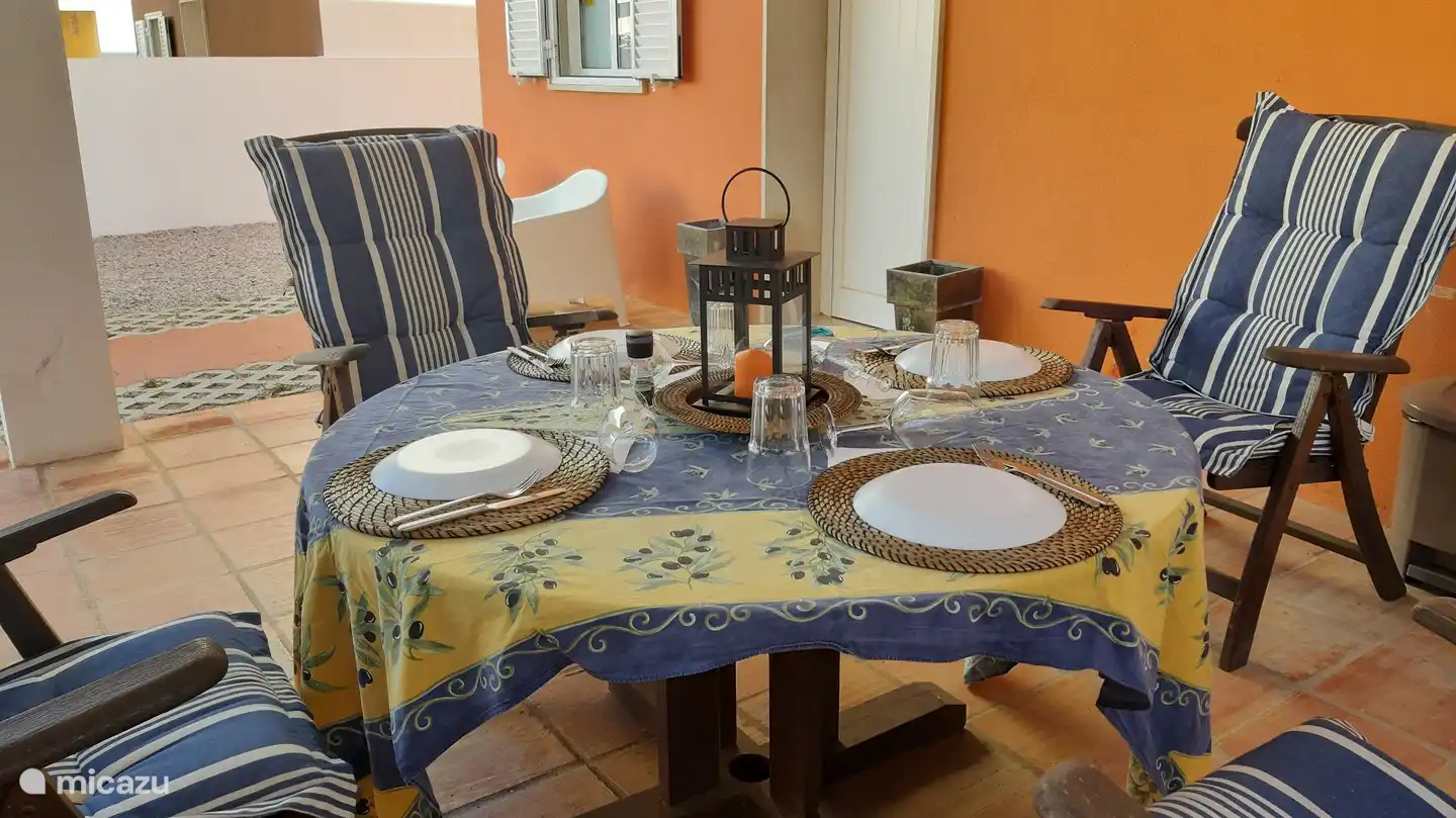 Willkommen im CASA ANANDA. Dies ist die Vorderseite des Hauses mit eigenem Parkplatz und einer angenehmen, immer schattigen Terrasse mit Esstisch und Stühlen aus Holz. Das ganze Haus ist eingezäunt, also absolute Privatsphäre.