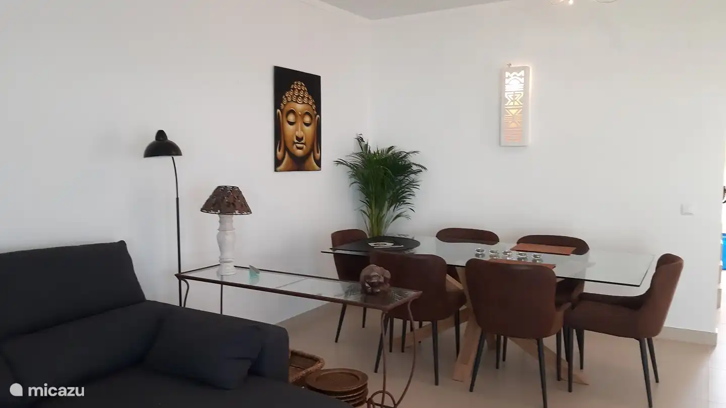 Gemütlicher Essbereich mit großem Esstisch aus Glas und 6 bequemen Sesseln