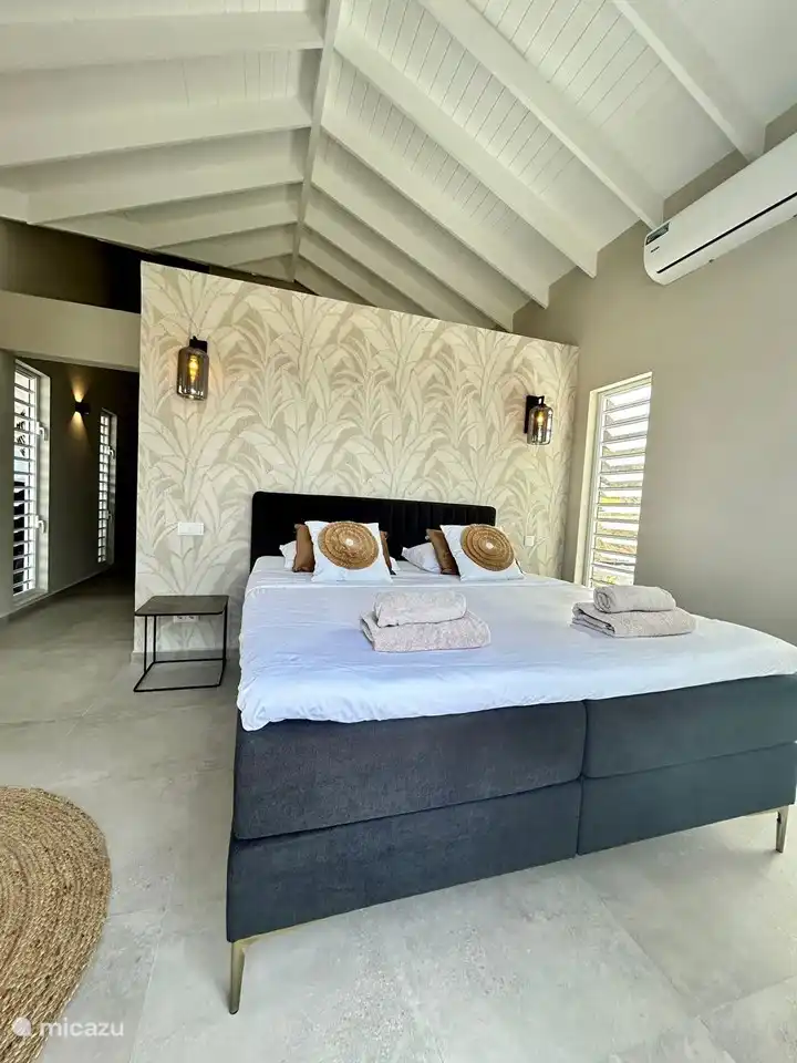 Chambre avec belles grandes armoires encastrées et salle de bain en suite.