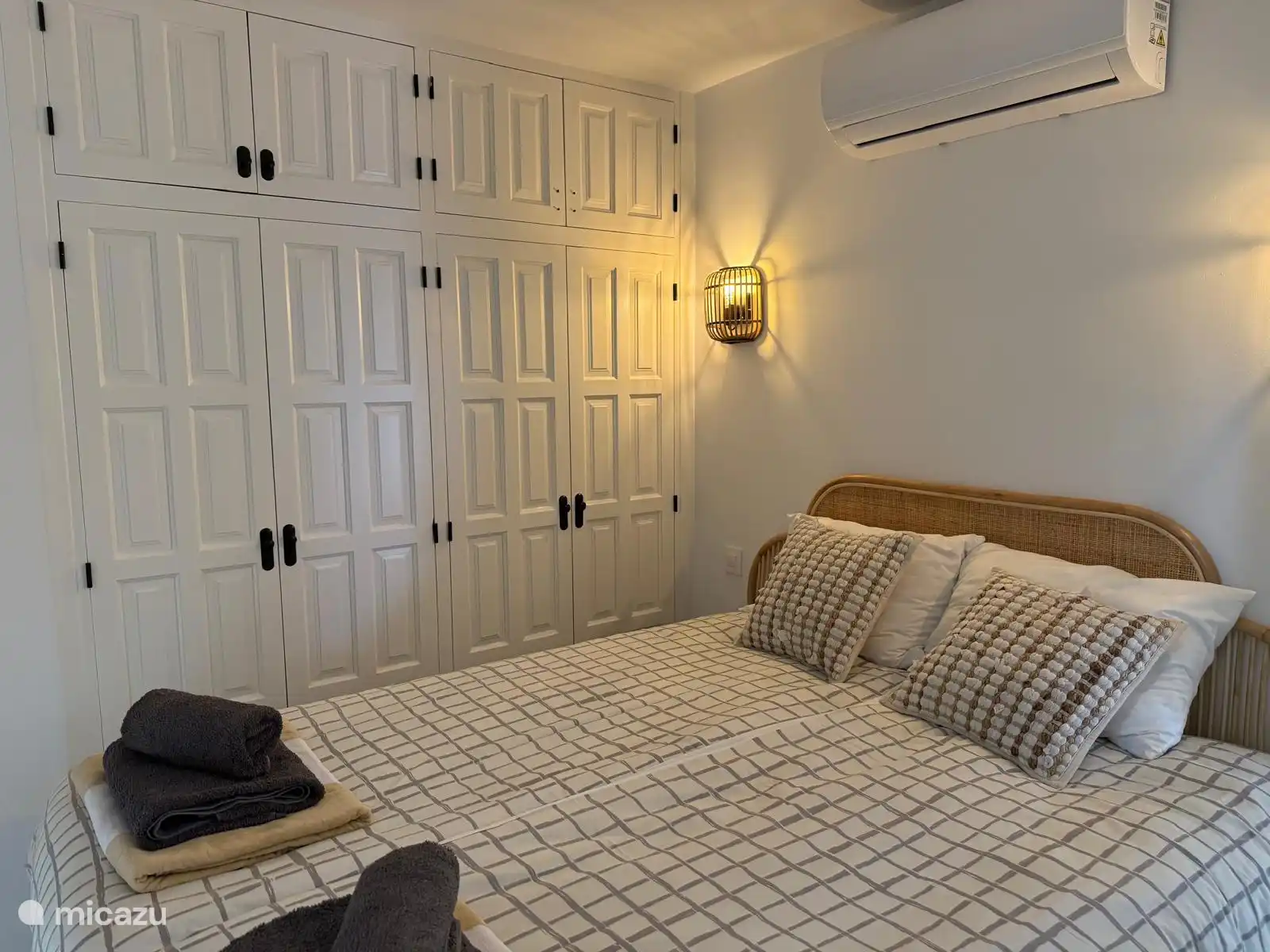 1 of the 2 bedrooms in the apartment with air conditioning and fan