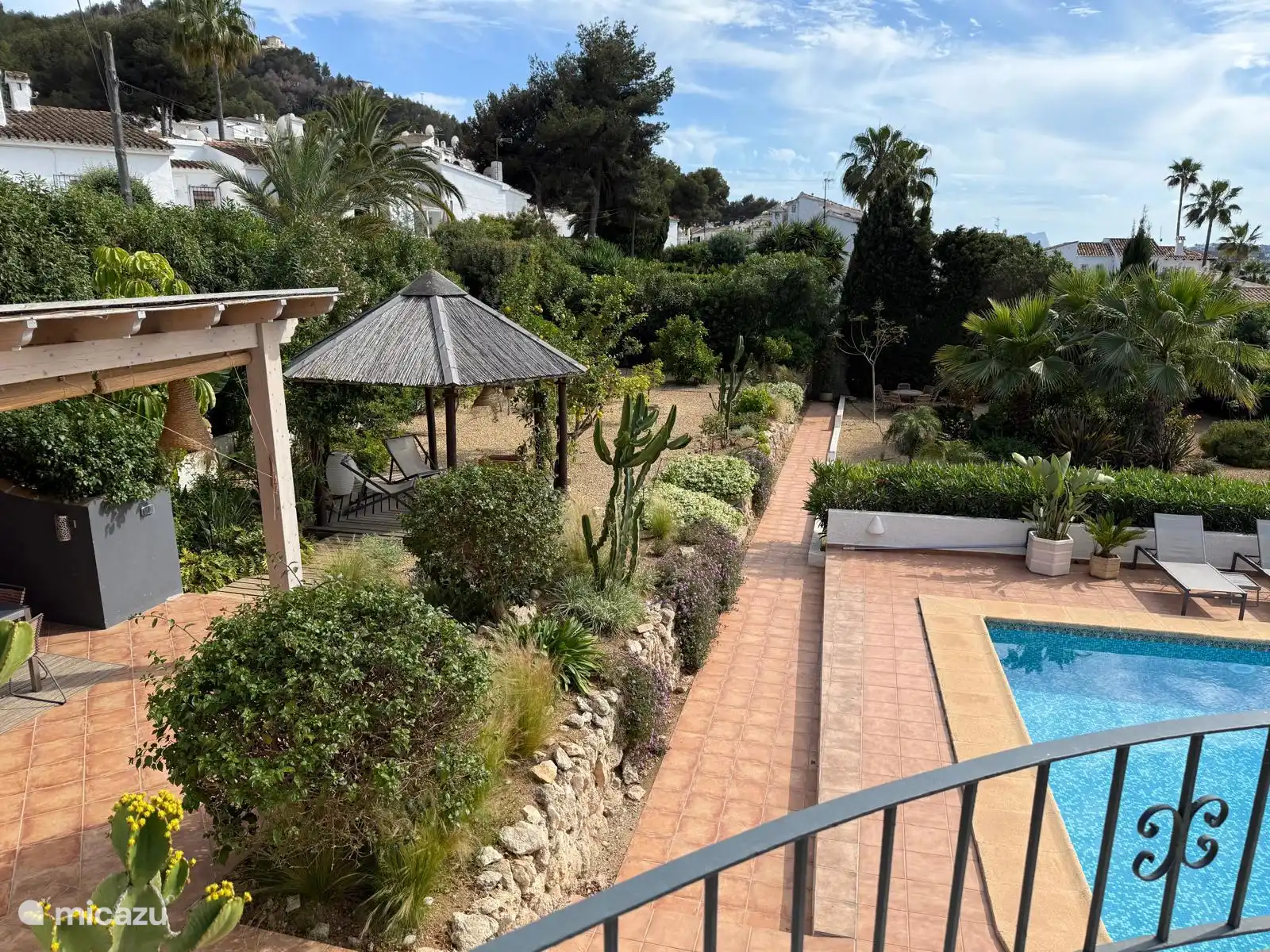 The pool is adjacent to several covered terraces