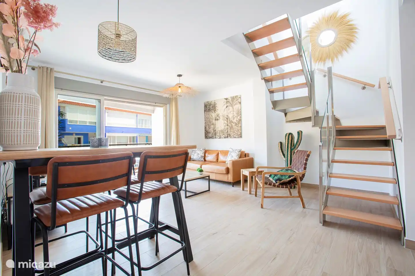 Séjour avec balcon et escalier vers la terrasse sur le toit