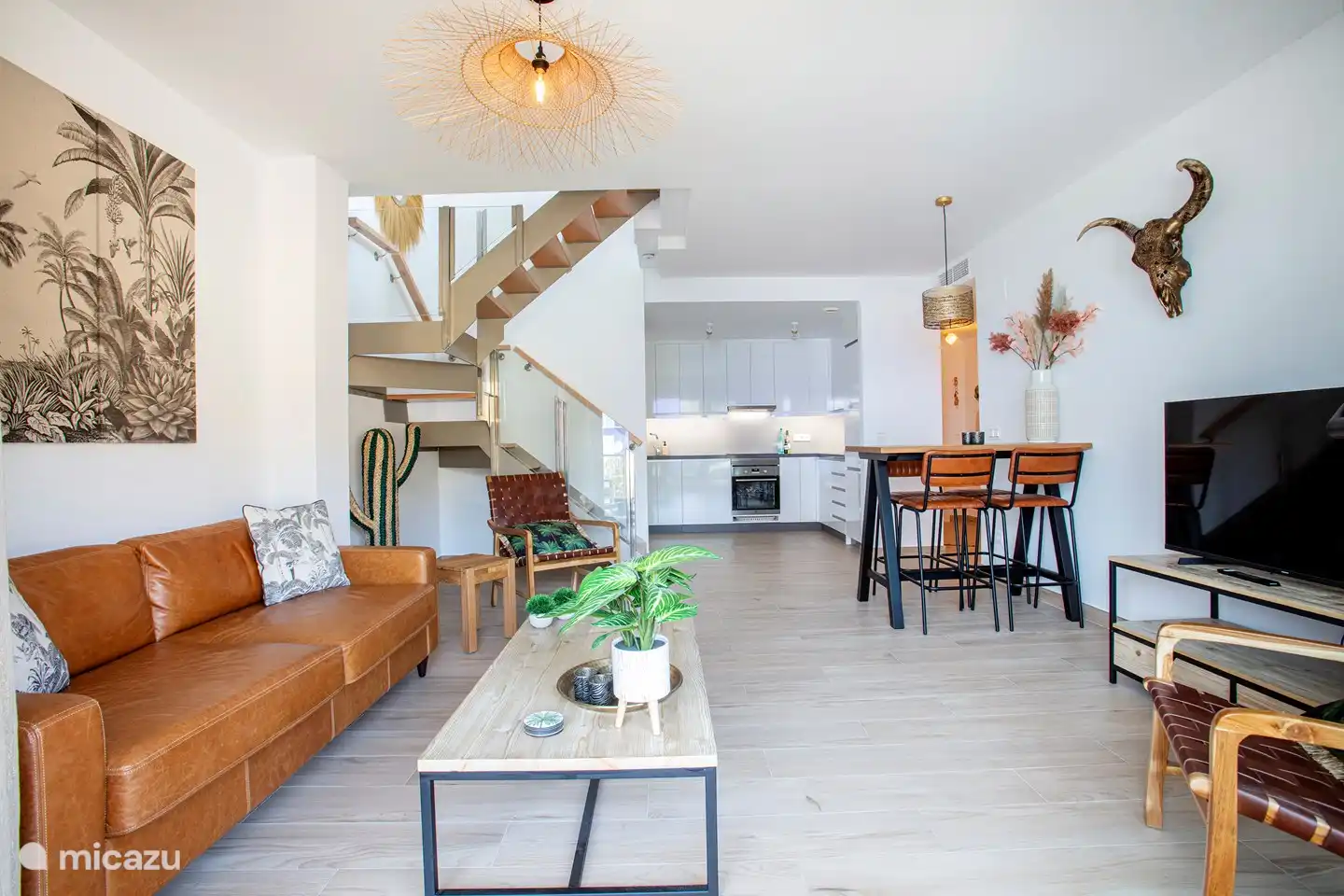 Salon spacieux avec cuisine ouverte et escalier menant à la terrasse sur le toit