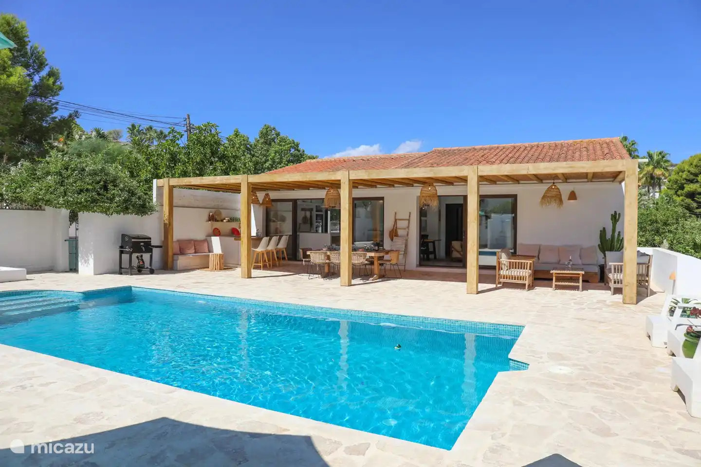 Geräumiger privater Swimmingpool, umgeben von Liegestühlen und Sonnenschirmen.