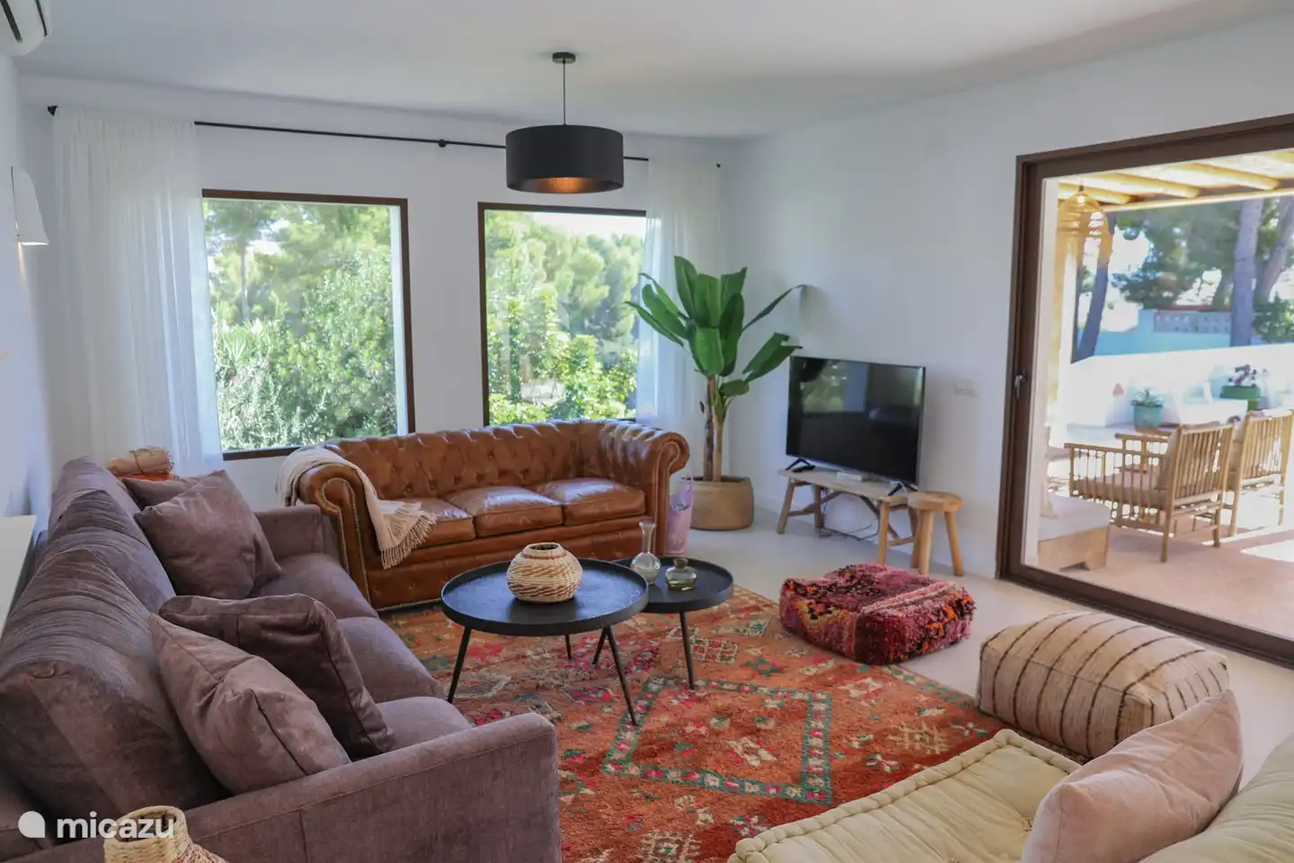 Wohnzimmer mit Sitzecke und Fernseher.