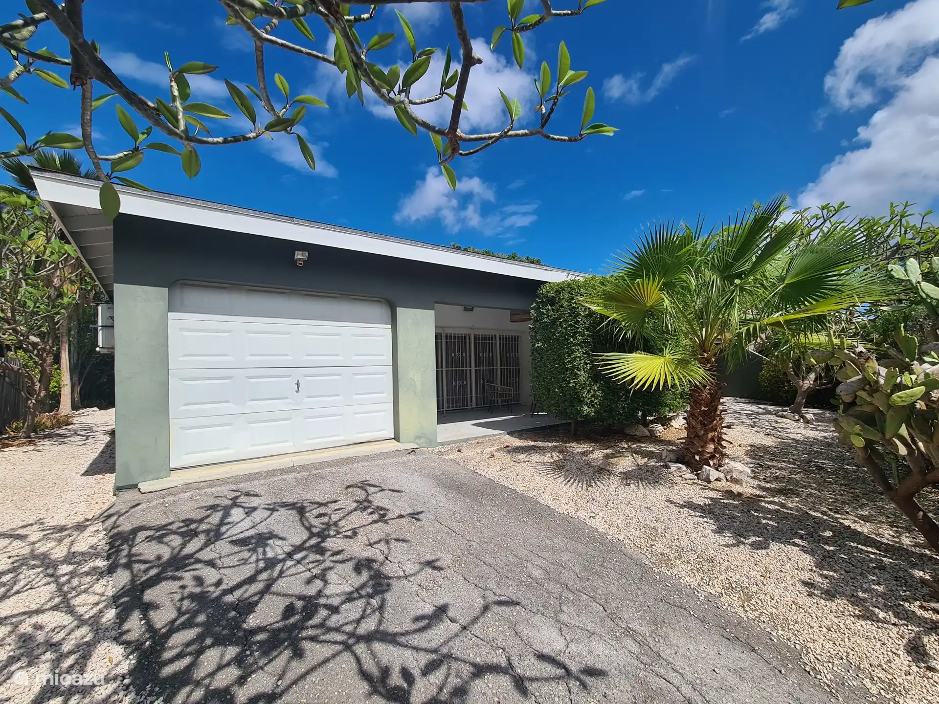 Un garaje privado y un jardín tropical rodean toda la casa. 