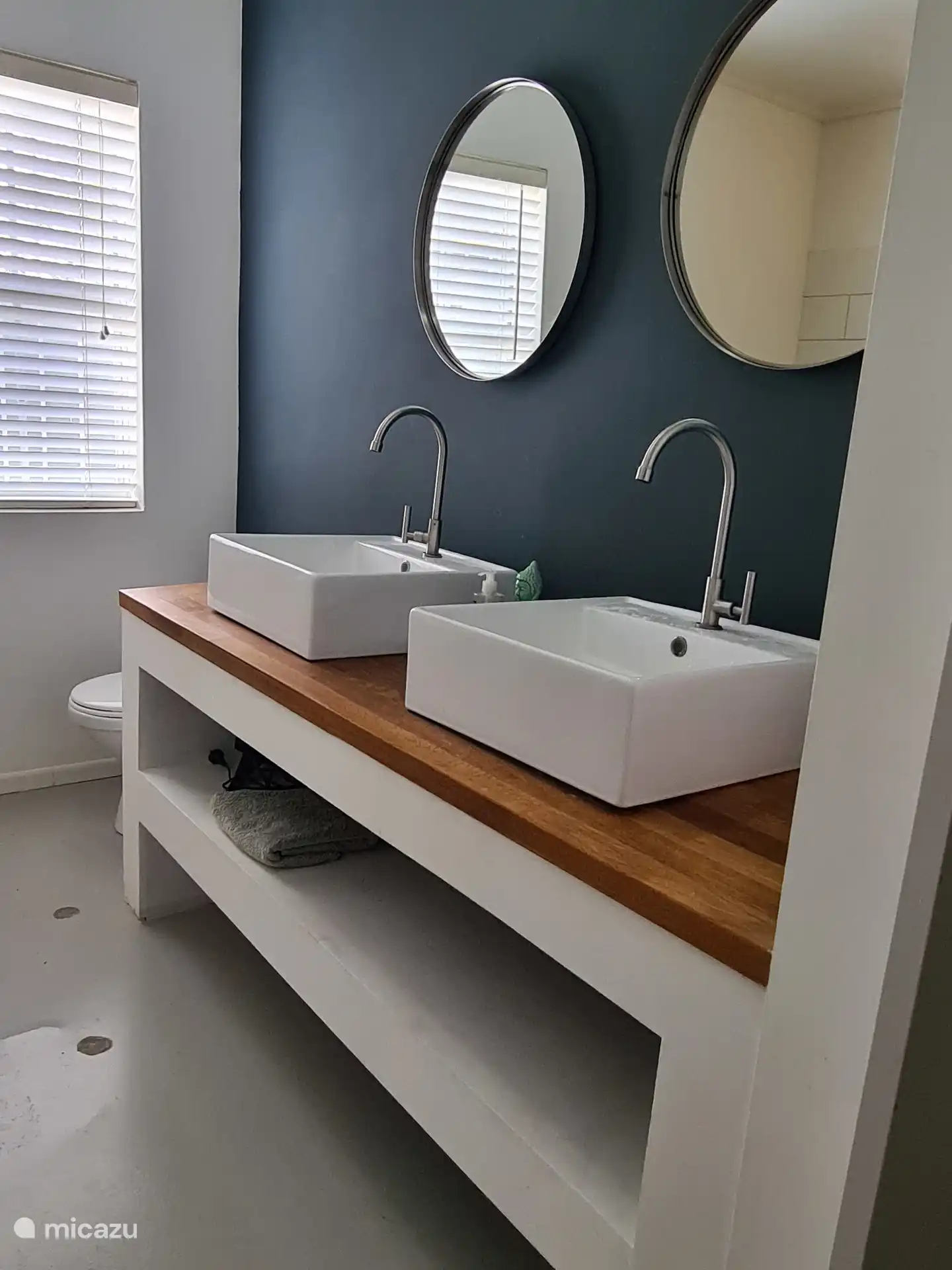 Baño del dormitorio principal, con dos lavabos, inodoro y ducha espaciosa.