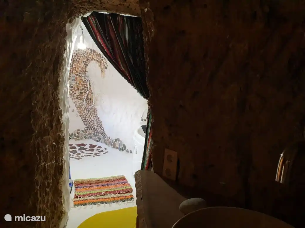 Das besondere Badezimmer besteht aus 2 hintereinander liegenden Räumen. Der hintere Raum mit Tageslicht verfügt über eine Regendusche und einen Whirlpool und ist kreativ mit Muscheln und roten Trittsteinen aus der Umgebung dekoriert