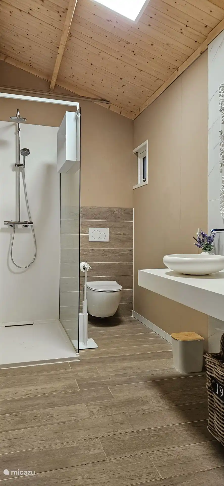 El cuarto de baño con ducha a ras de suelo, inodoro y lavabo 