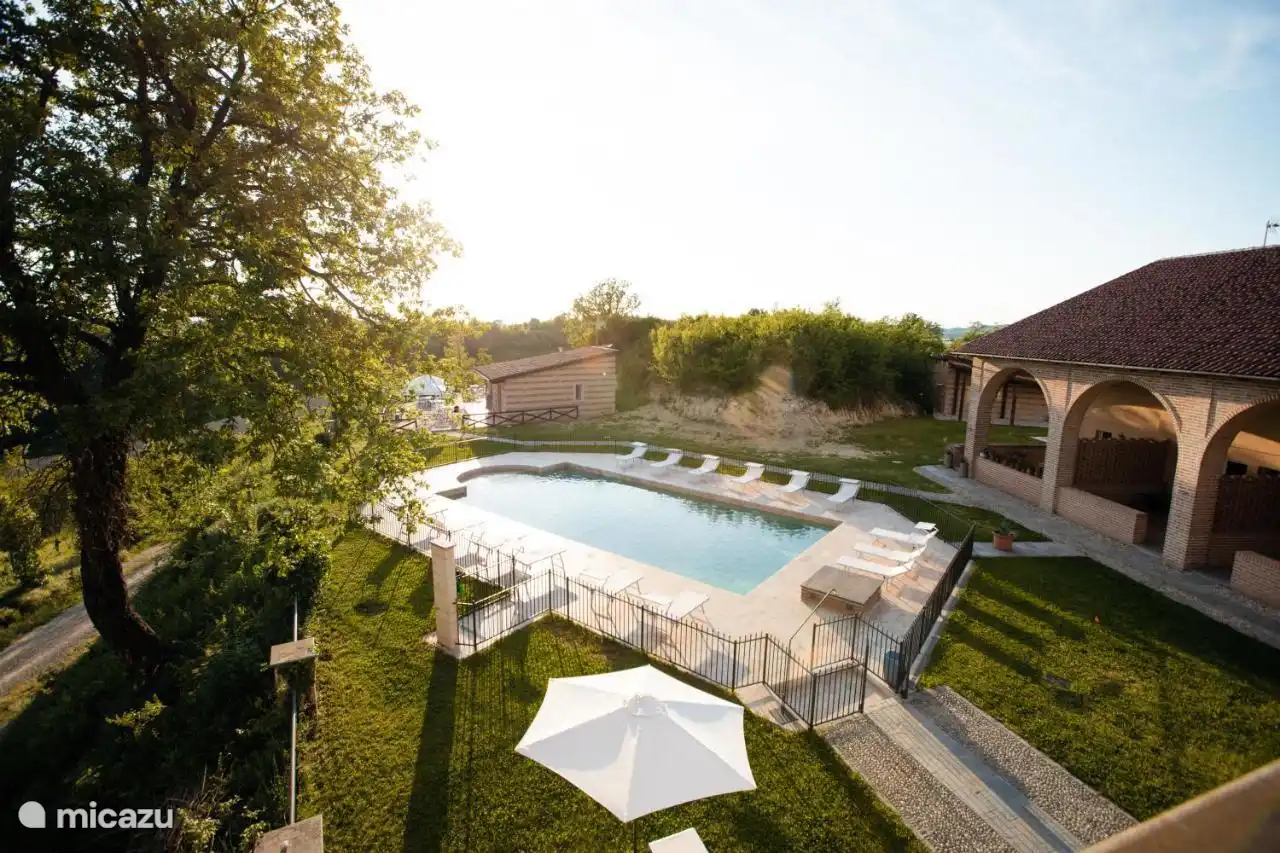 Vista desde el balcón a la piscina y parte del jardín