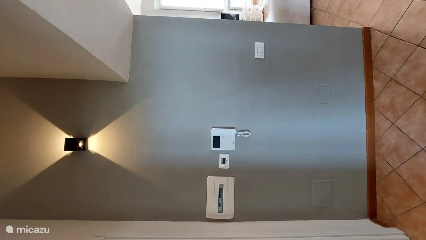 Salón con intercomunicador, calefacción central e interruptores. También hay un detector de humo y un detector de dióxido.