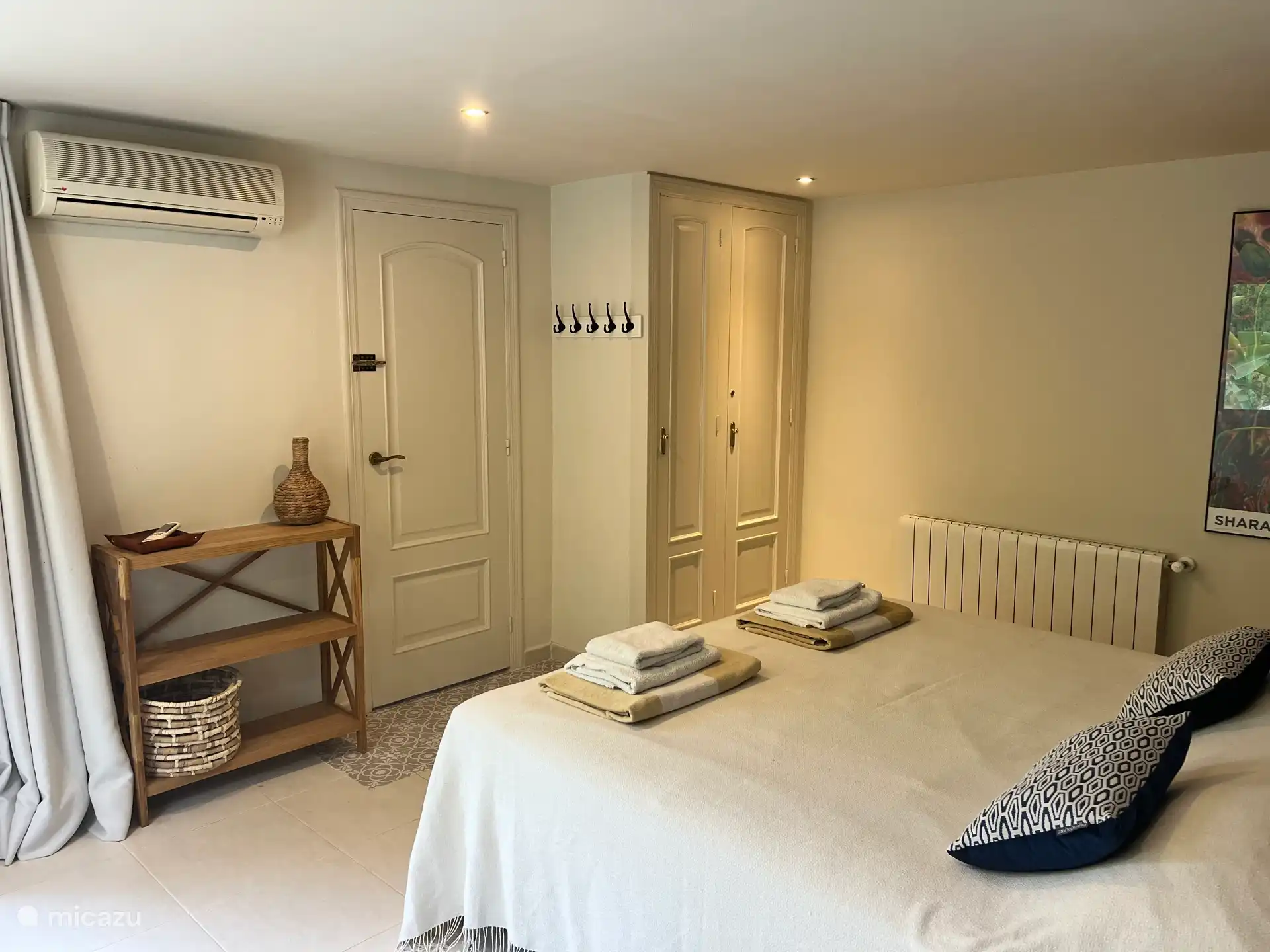 Schlafzimmer 4 im Untergeschoss mit bequemem Doppelbett, Klimaanlage und geräumigem Kleiderschrank