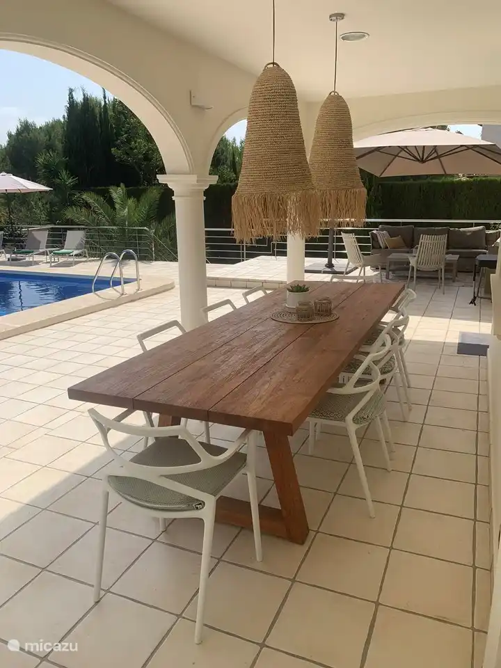 Überdachte Terrasse mit großem Esstisch und Markise