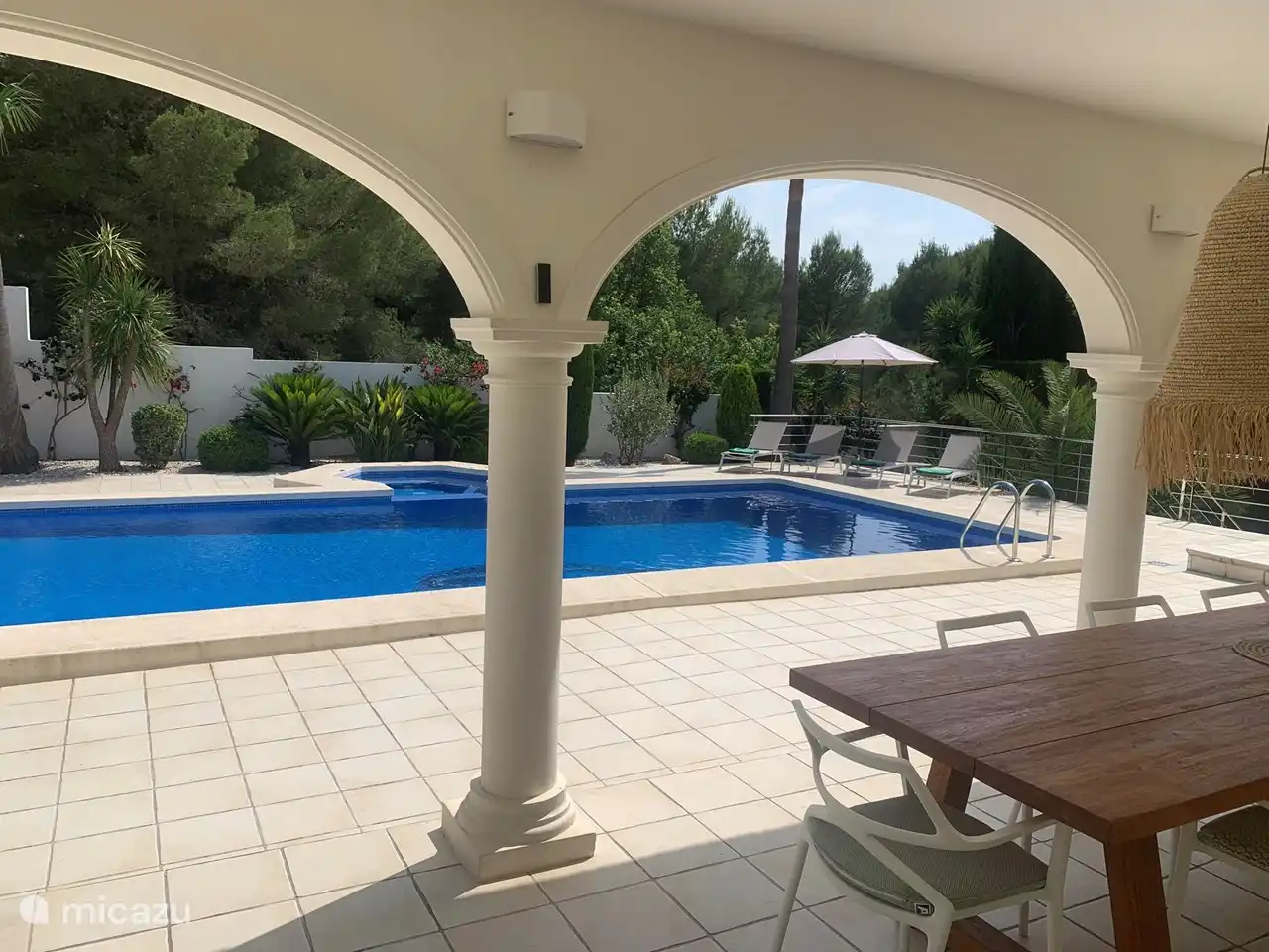 Blick von der Terrasse auf den Garten und den Pool