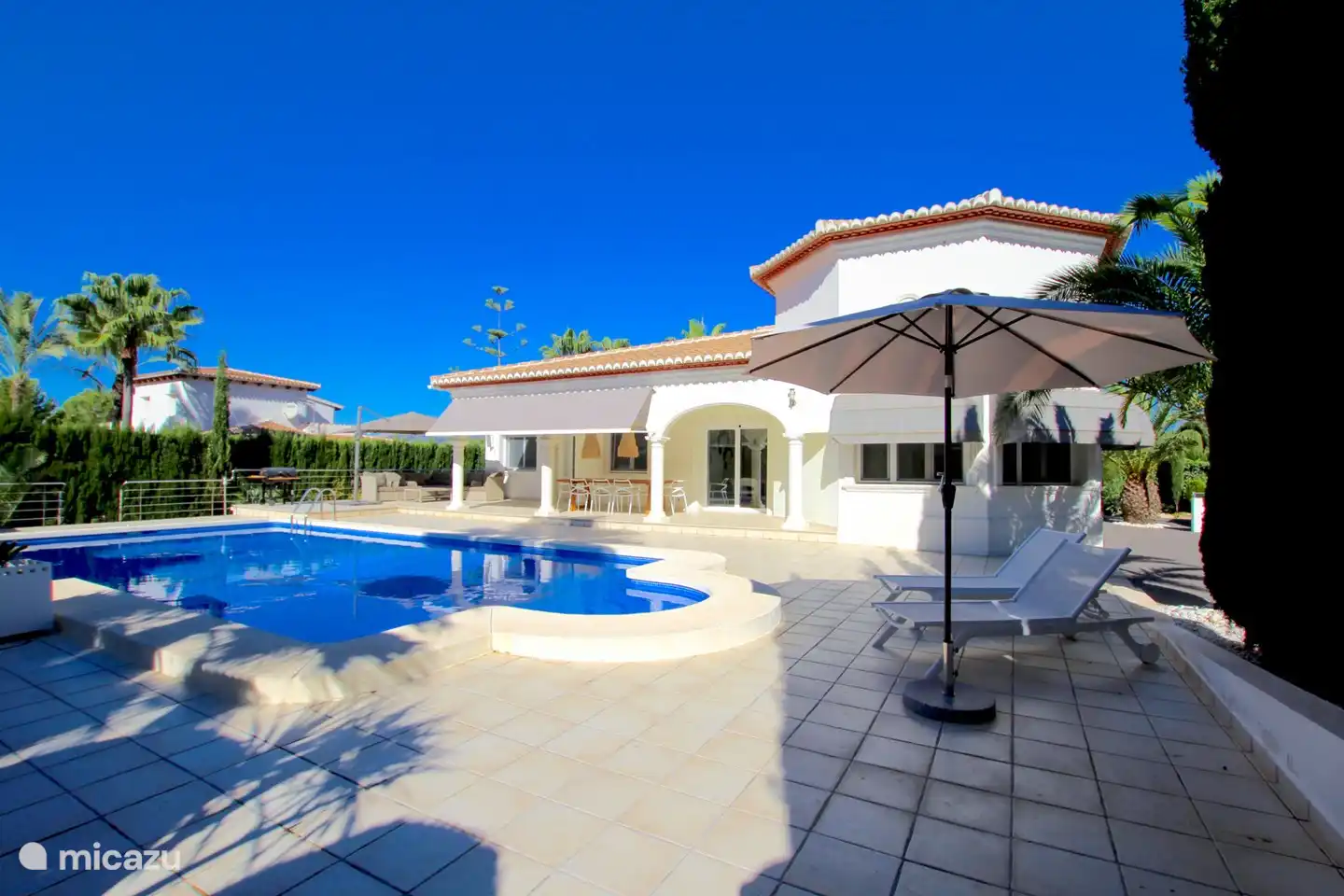 Rechts vorne mit Sonnenliegen und Sonnenschirm