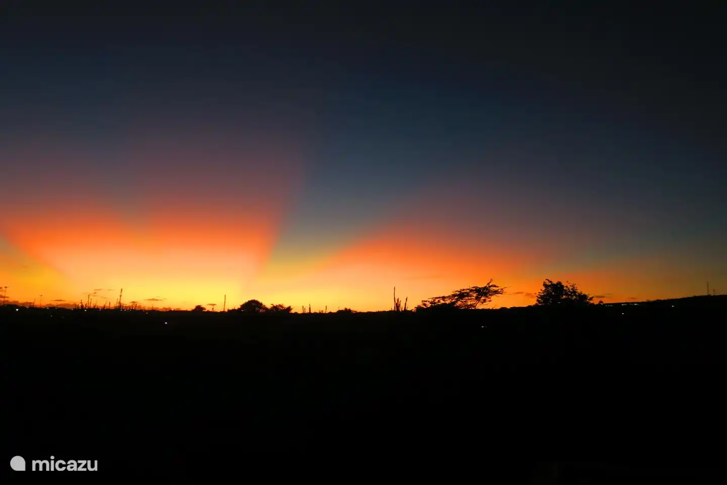 Vom Balkon aus können Sie die untergehende Sonne sehen.