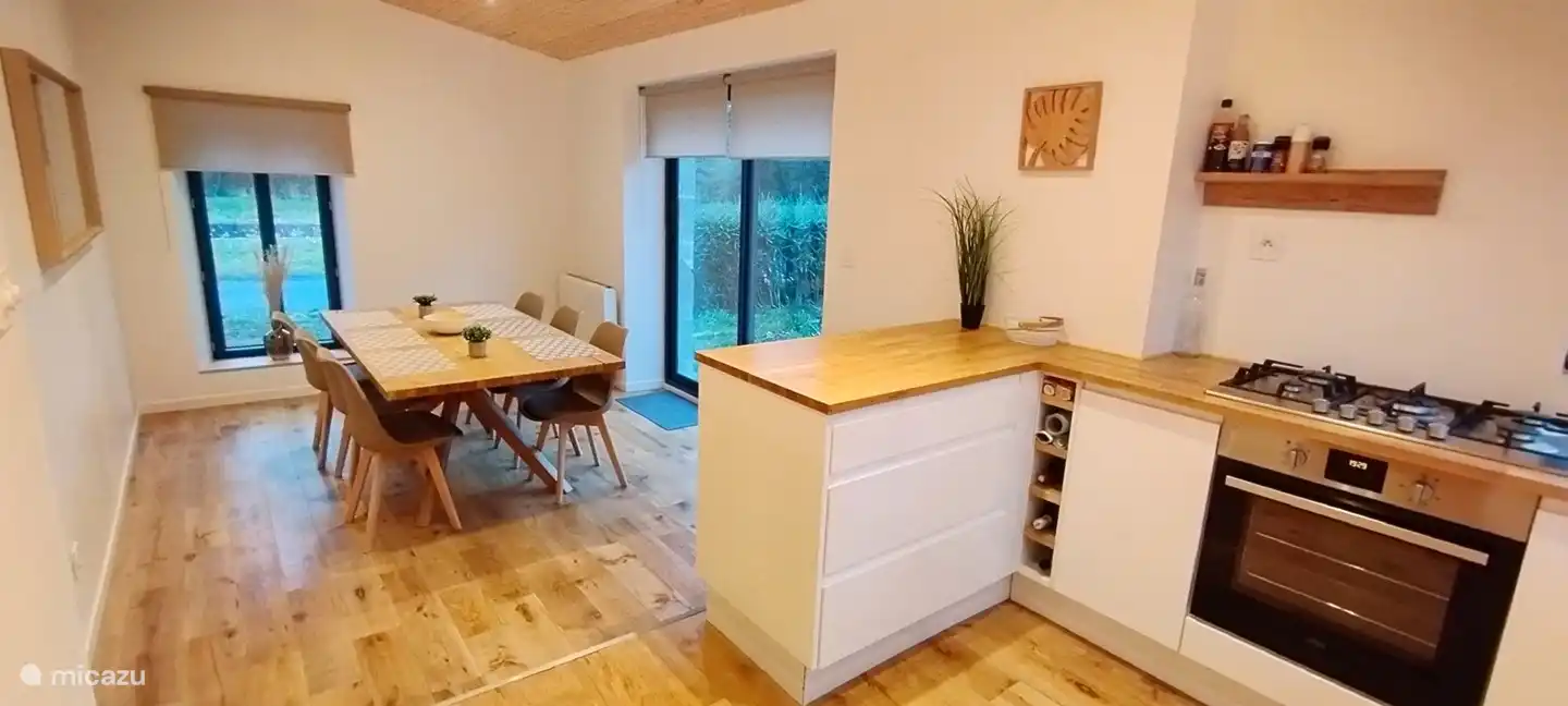 open ruime moderne keuken met eettafel en toegang tot het zuidelijke terras via schuifraam