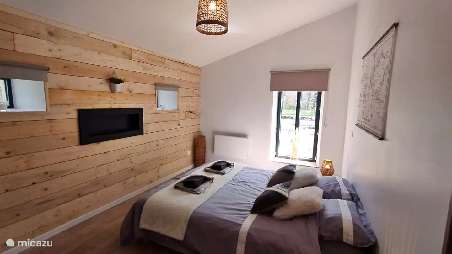 slaapkamer met dubbel bed op de beneden verdieping en bio ethanol kachel voor de gezelligheid