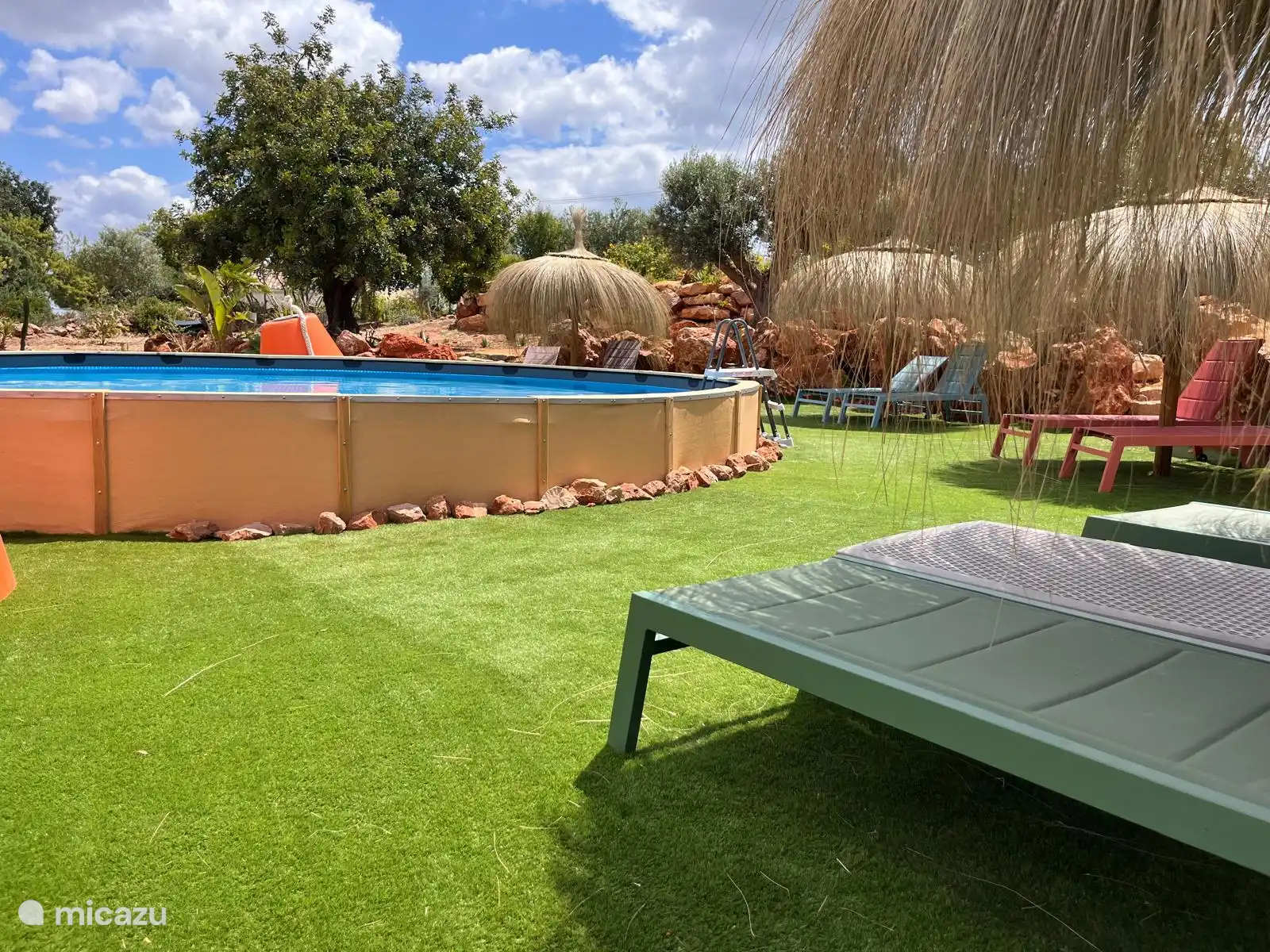 swimming pool with sun loungers and parasols