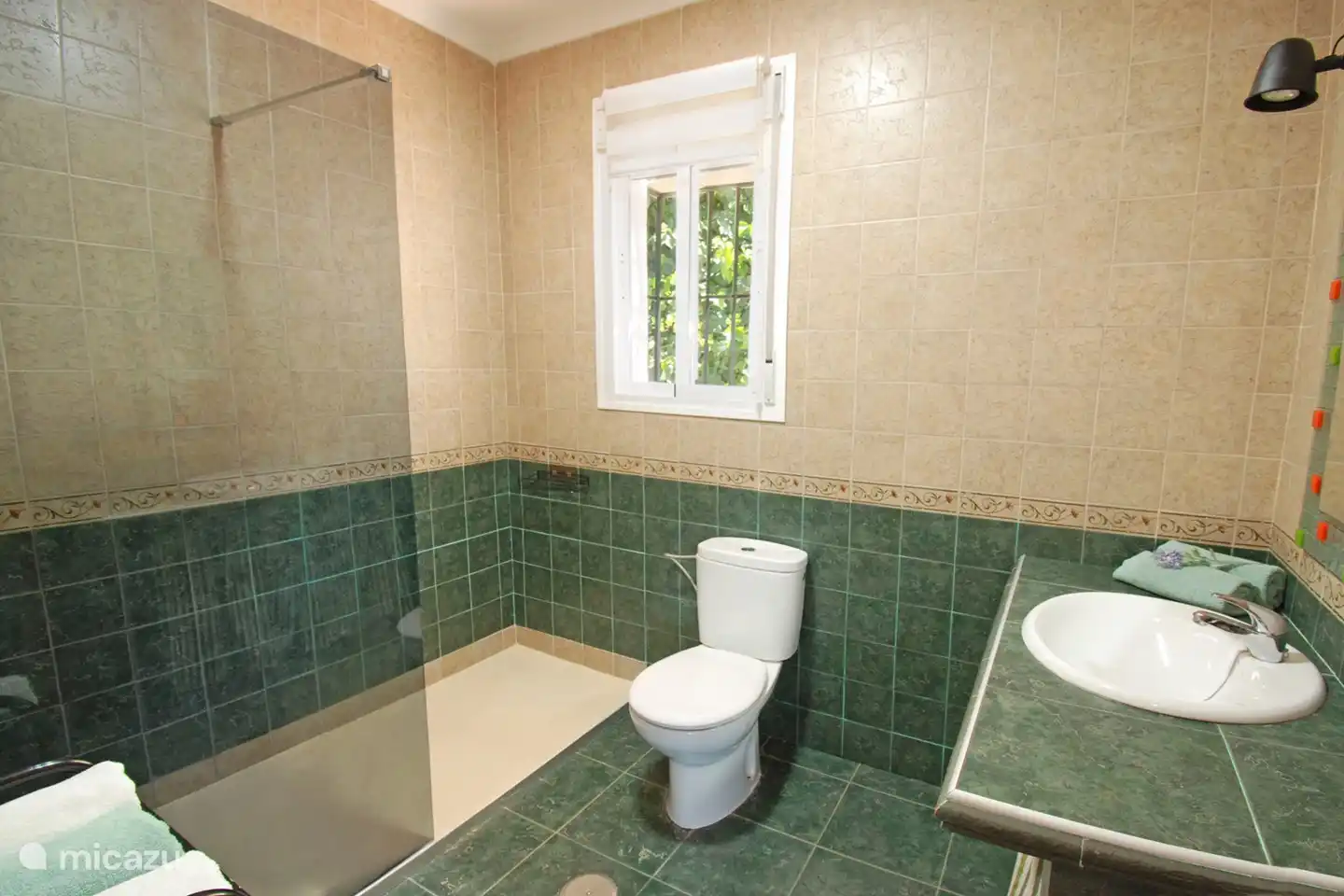 De badkamer is volledig betegeld en heeft een ruime 
inloop-douche. 