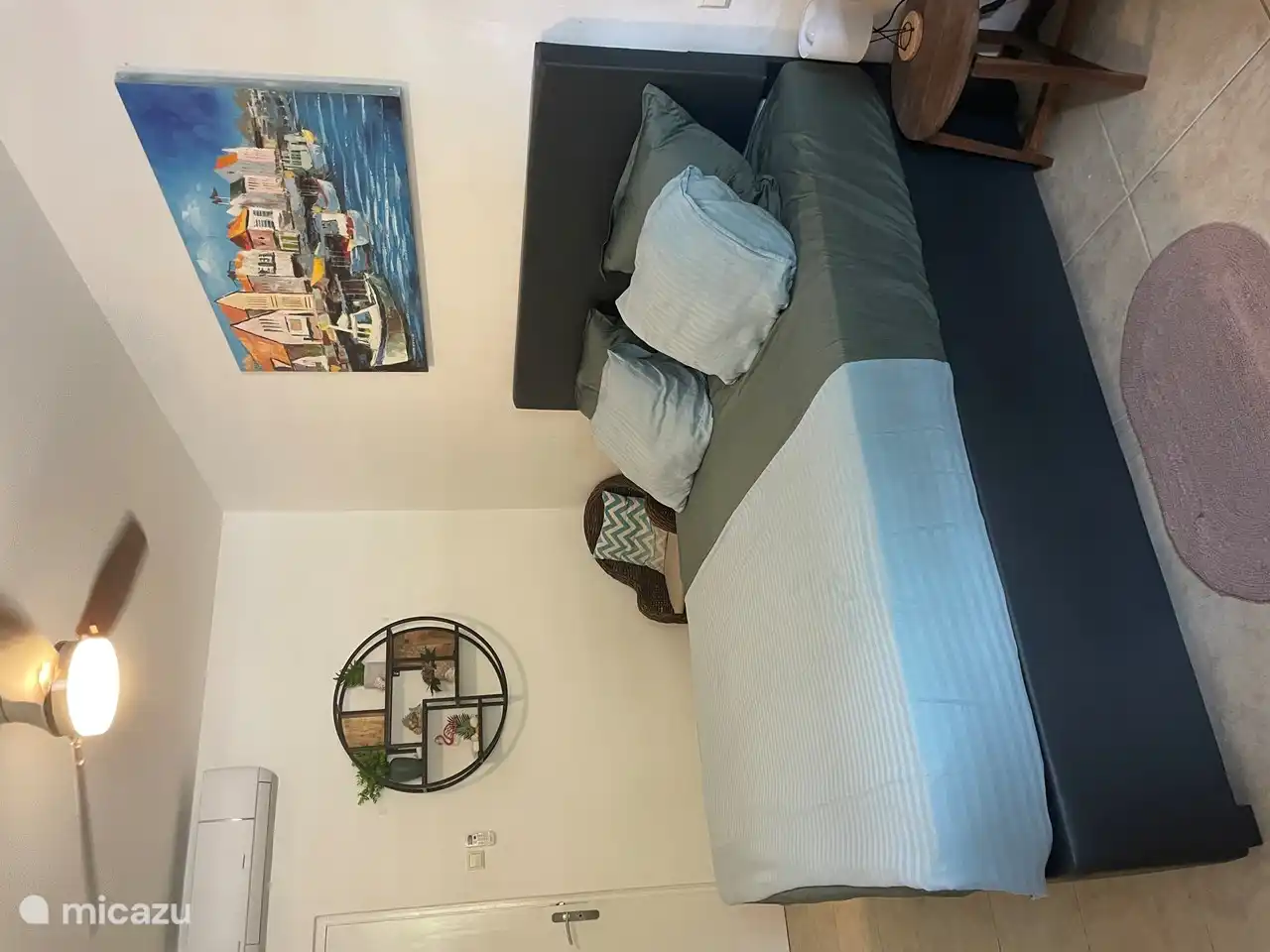 The bedroom has air conditioning and a ceiling fan