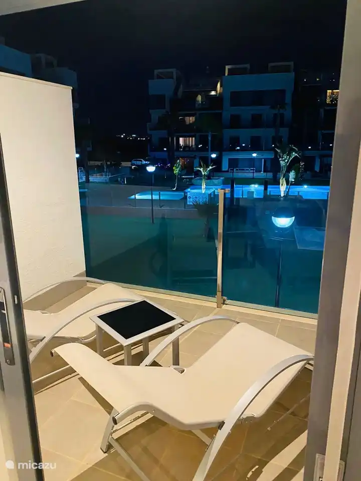 vue de la chambre double de l'appartement sur la terrasse et la piscine