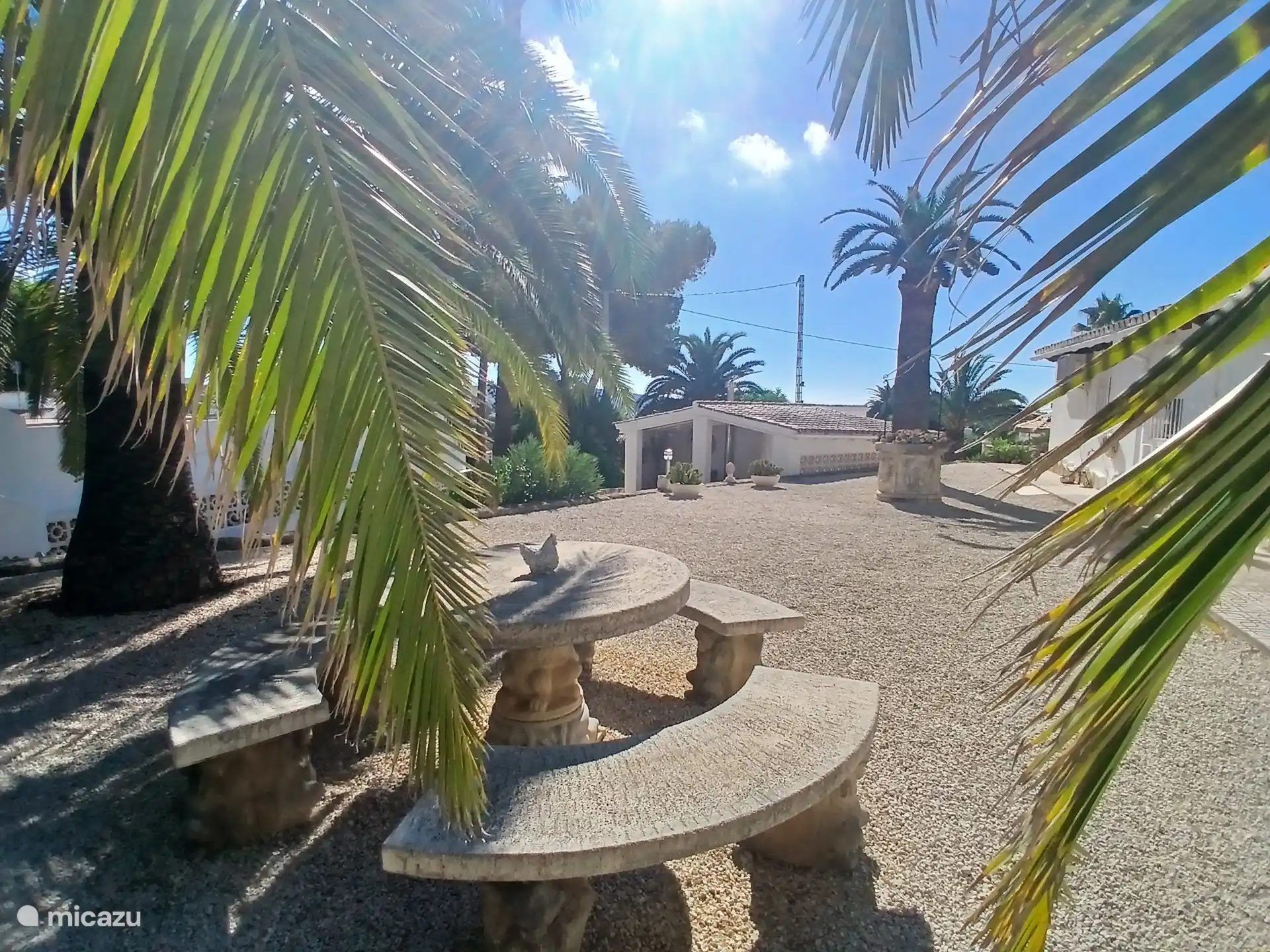 Backyard with a view of the carport and covered sitting area.
