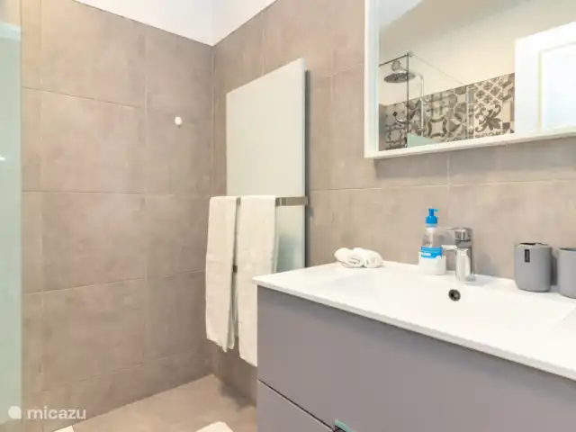 Casa Encantada Carvoeiro Algarve en Portugal, Algarve, Carvoeiro - apartamento El baño fue completamente renovado en 2024. Por supuesto, con una ducha a ras de suelo con ducha de lluvia. El cuarto de baño dispone de calefactor de infrarrojos. En verano no se usa mucho pero en invierno es muy cómodo! Los muebles de lavandería tienen un secador de pelo y mucho espacio de almacenamiento.