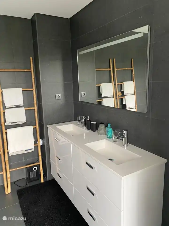 Badezimmer im Hauptschlafzimmer: Doppelwaschbecken, große Badewanne, Toilette und Handtücher vorhanden