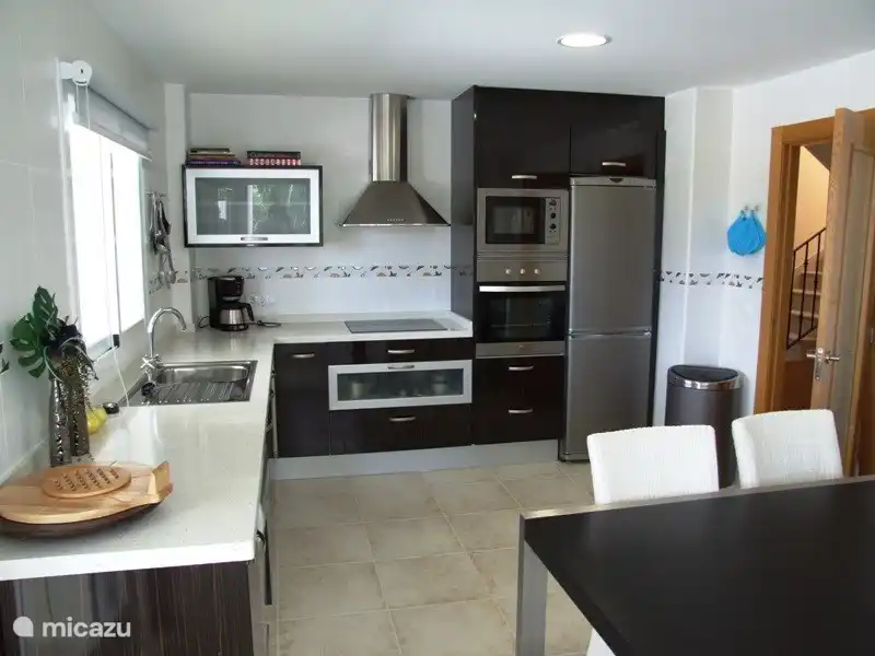 Belle cuisine séparée spacieuse avec porte sur la terrasse