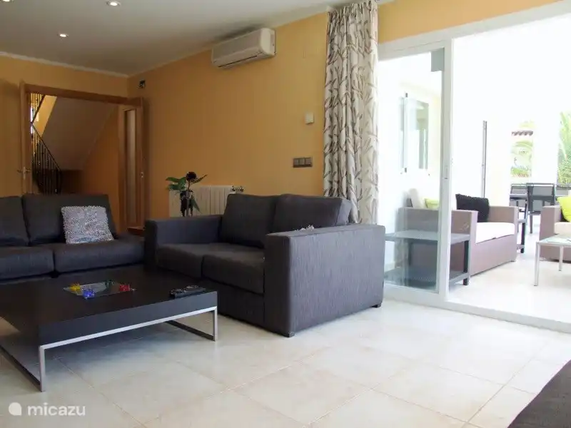 Depuis le salon, vous pouvez accéder à la spacieuse terrasse couverte par les portes coulissantes