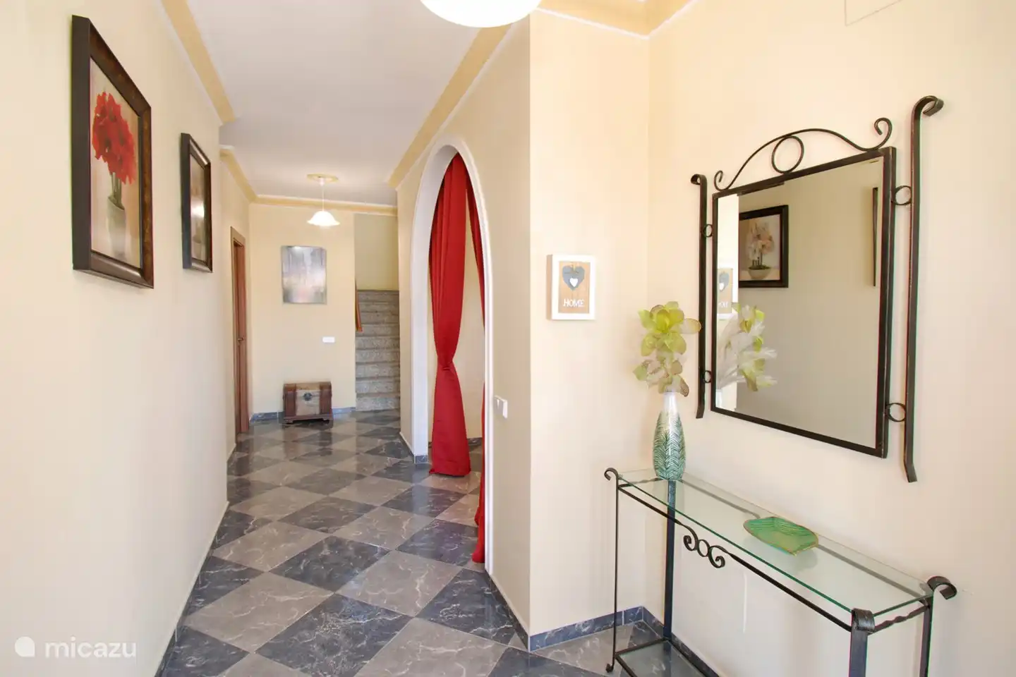 Via de hal leiden we je het huis binnen.