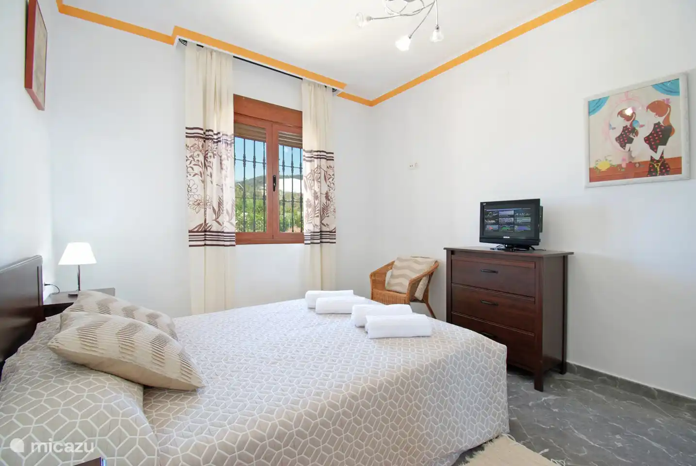 Ook op het gelijkvloers, deze slaapkamer met tv en kleerkast.