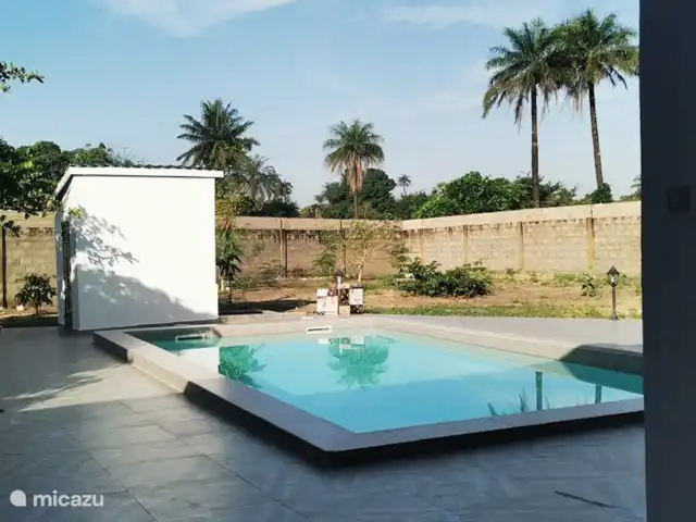 Maison du jardin fleuri | Gambie, Région côtière, Sanyang - villa La grande piscine avec le pool house sur lequel une belle peinture murale sera bientôt visible. Le jardin est donc fini avec de l'herbe et de nombreux agrumes et plantes à fleurs