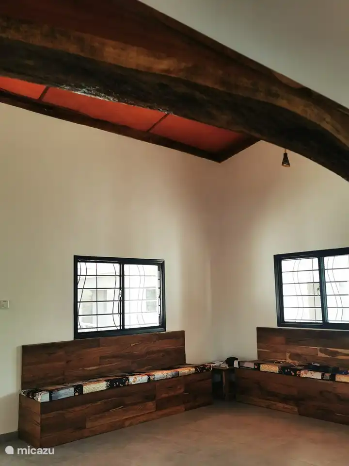 Von der Küche aus betreten Sie das Wohnzimmer mit eingebauten Sofas und einem Deckenventilator sowie die französischen Türen zur Rückseite des Hauses.