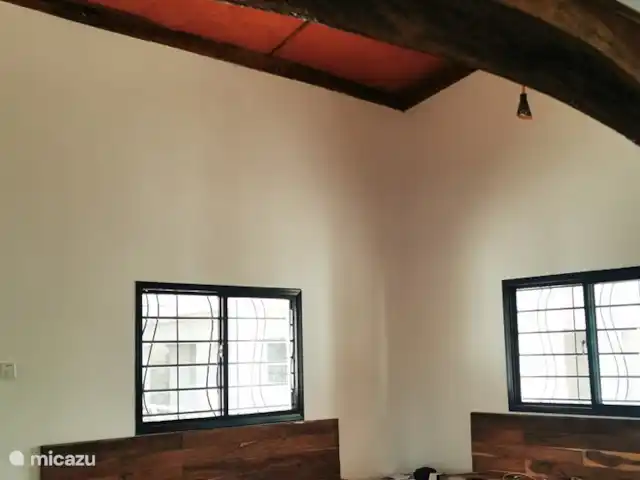 Maison du jardin fleuri | Gambie, Région côtière, Sanyang - villa De la cuisine, vous entrez dans le salon avec des canapés intégrés et un ventilateur de plafond et encore les portes françaises à l'arrière de la maison.