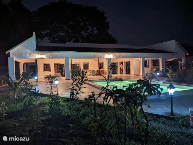 Maison du jardin fleuri | Gambie, Région côtière, Sanyang - villa Casa Lamar au crépuscule une vue du jardin sur la grande véranda et la piscine