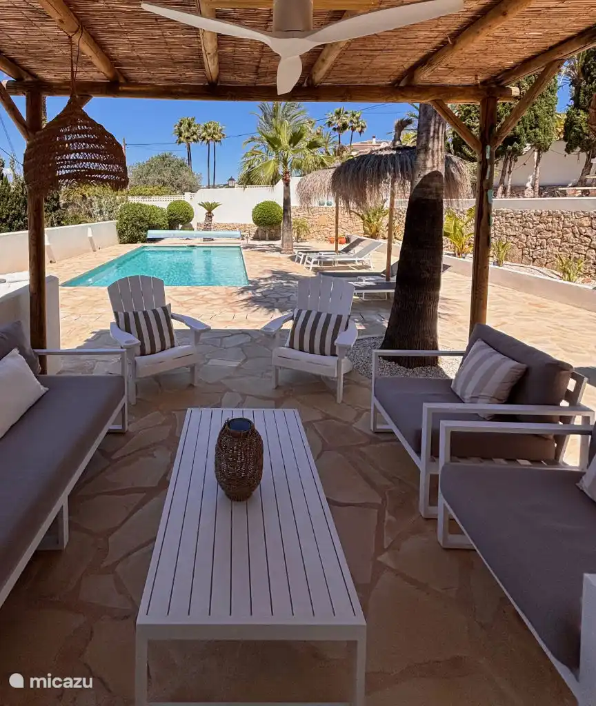 Bajo la pérgola en la terraza trasera puedes disfrutar de la sombra de la piscina