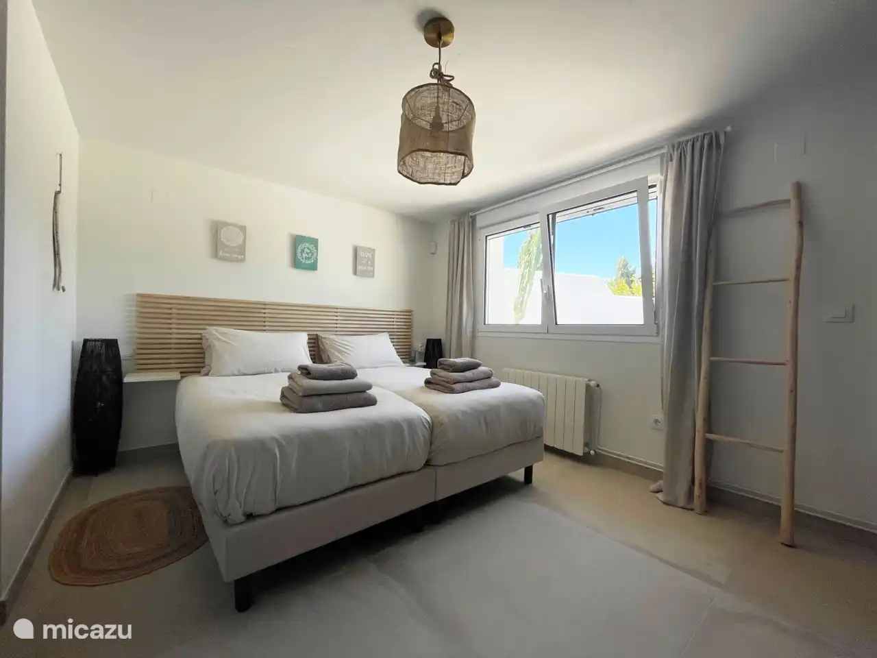 One of the two bedrooms downstairs has two single box-spring beds and a spacious en-suite bathroom. It also contains the washing machine and dryer.
