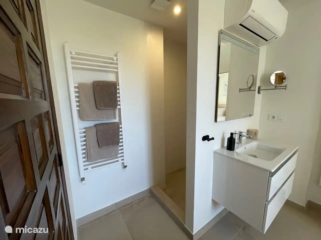 The second bedroom downstairs has a sink with drawer cupboard, walk-in shower and a separate toilet