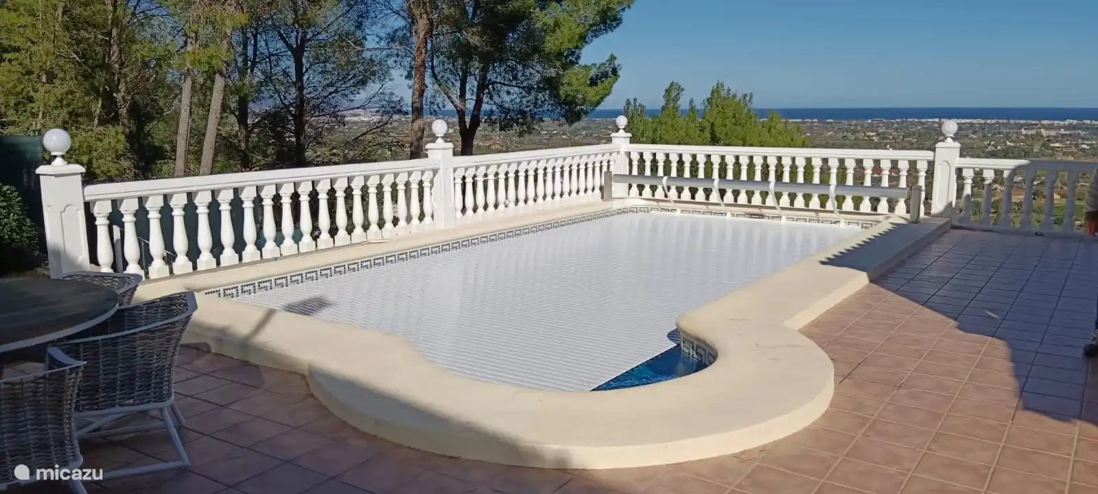 Piscine avec couverture fermée et mer Méditerranée en arrière-plan.