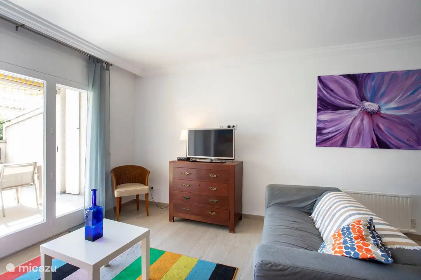 The living room with two benches (3p) and patio doors to the terrace