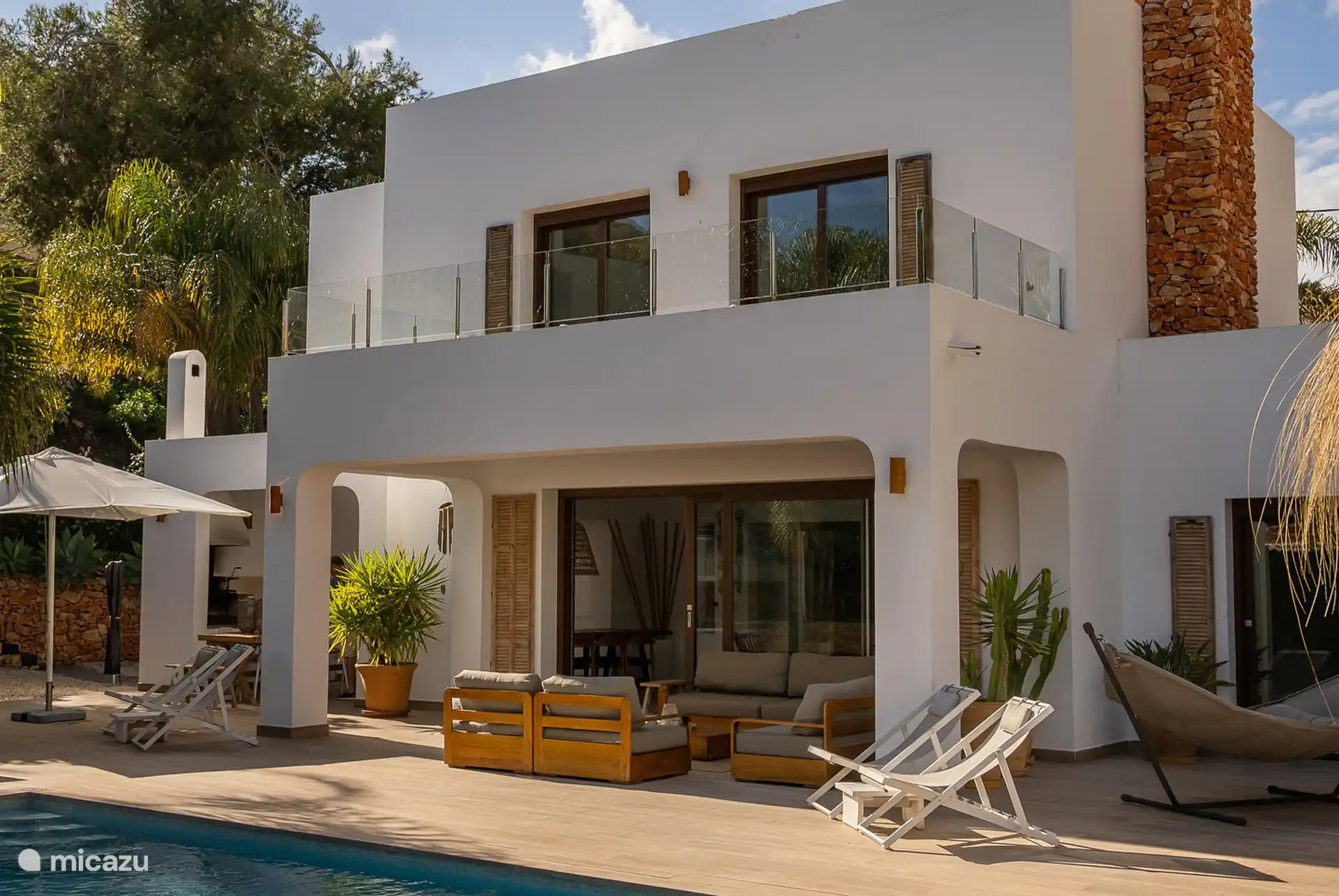 Backyard of Villa Azuro with lounge set, sun loungers, outdoor kitchen and hammock