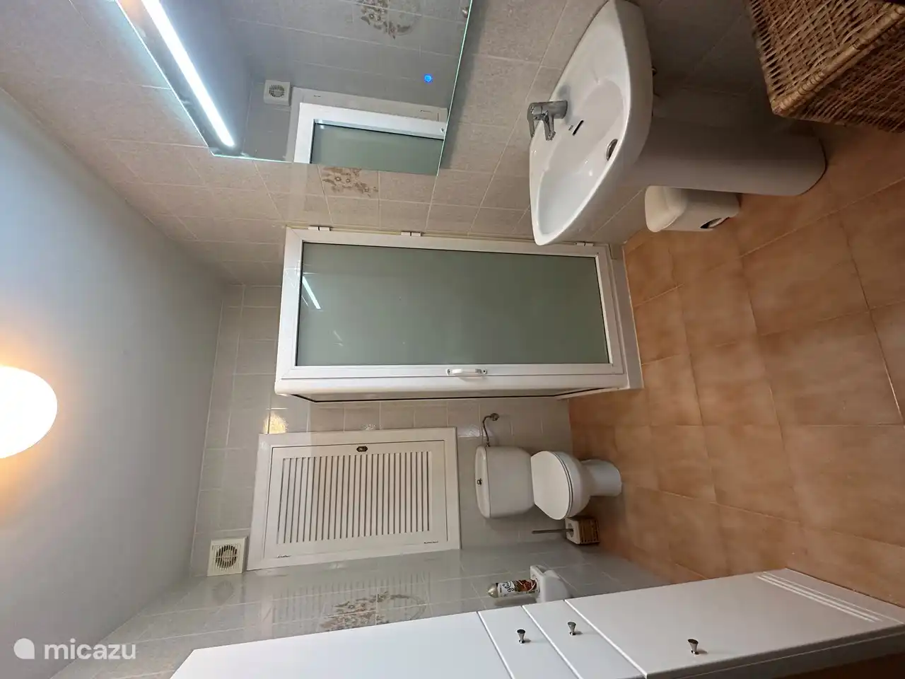 Das Badezimmer im Erdgeschoss mit Toilette, Waschtisch und Duschkabine.