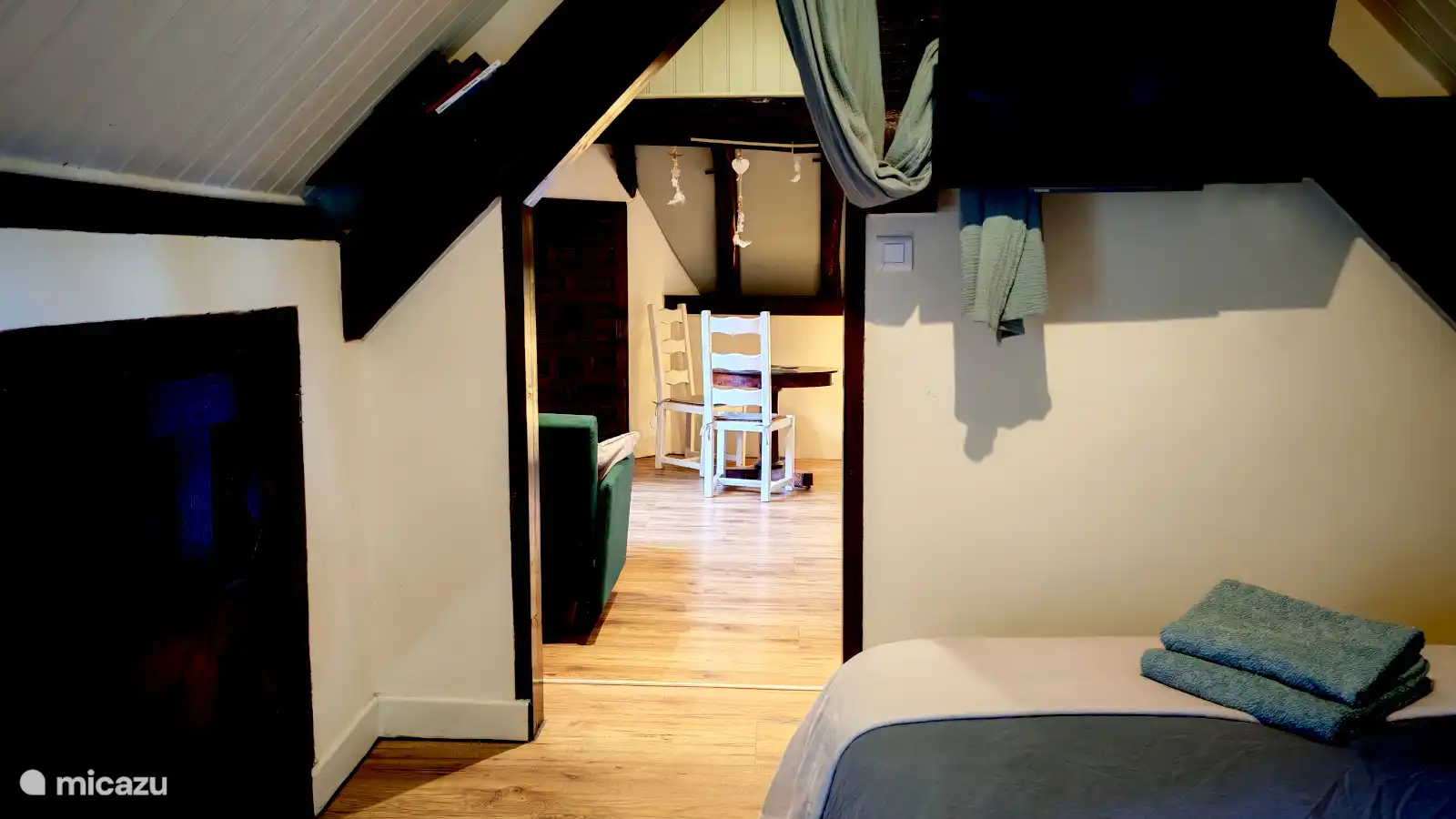 Doorkijkje van bed naar woonruimte. Studio Vert d'Eau